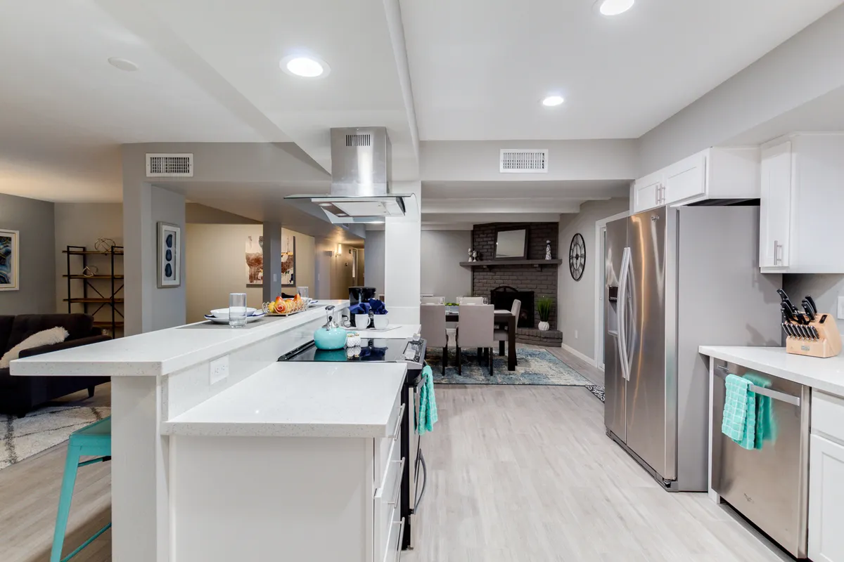 The photo focuses on the kitchen island and flows to the dining area, with a highlight on the adjacent fireplace. The setup is ideal for family gatherings, festive dinners, and memorable social occasions, showing both the culinary and dining experience.
